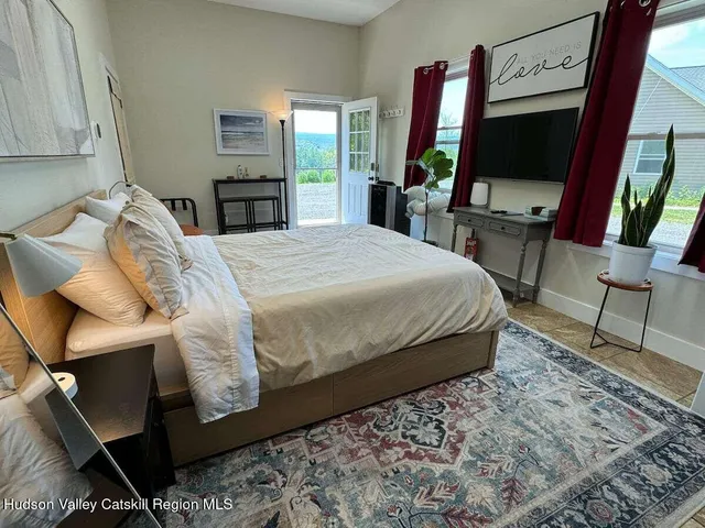 a large bed sitting in a bedroom next to a window
