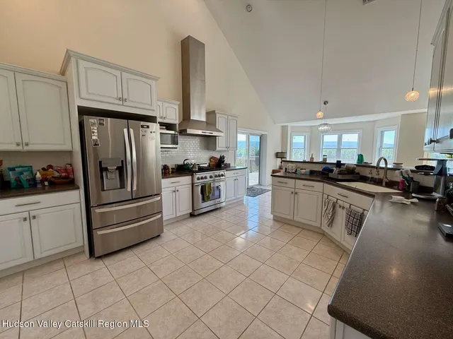 a kitchen with granite countertop a refrigerator stove top oven and sink