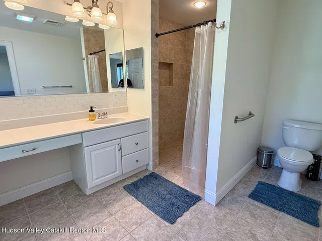a spacious bathroom with a double vanity sink toilet and shower