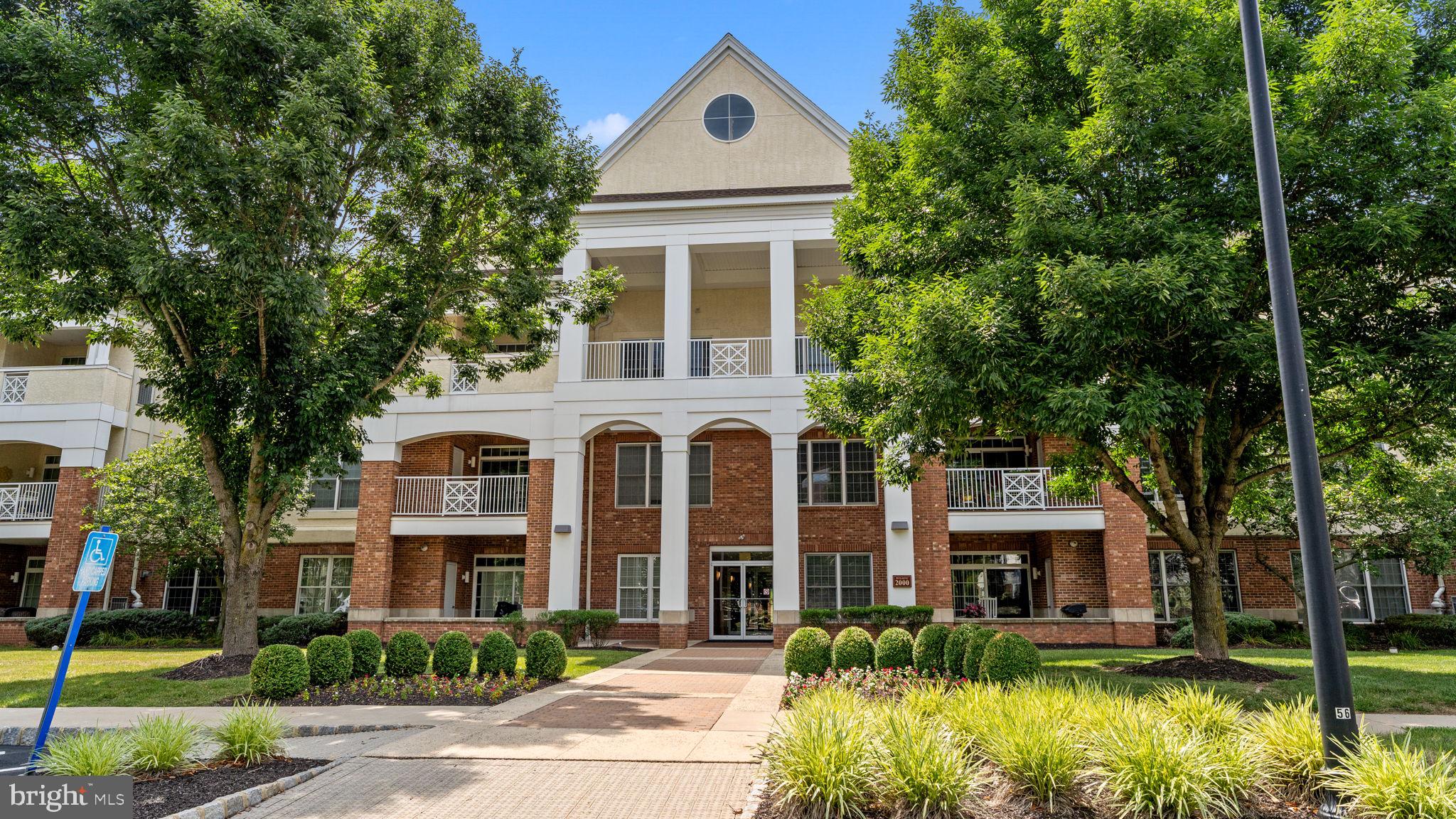 a front view of a house with a yard and potted plants