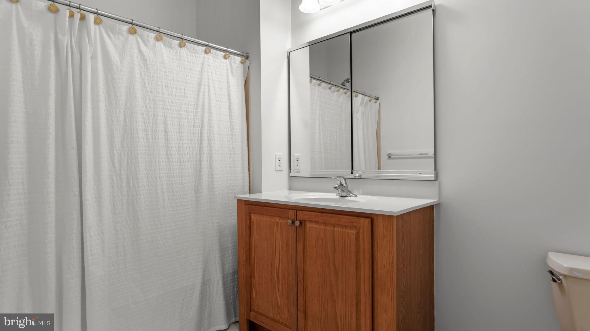 2102 Meridian Boulevard Warrington, PA 18976 - Photo 22 of 29 a bathroom with a mirror and a shower curtain
