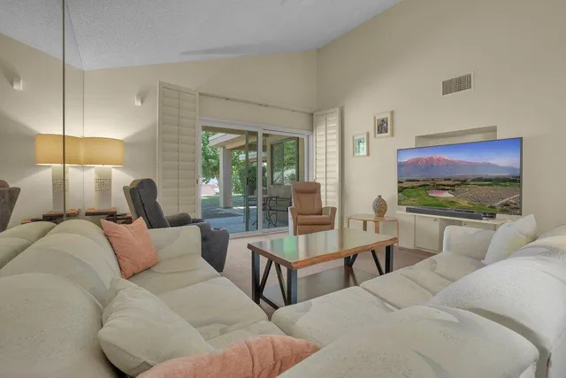a living room with furniture a lamp and a flat screen tv