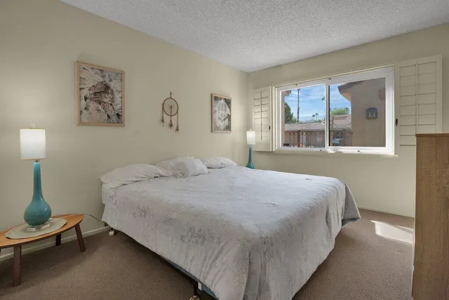 a bedroom with a bed and a large mirror