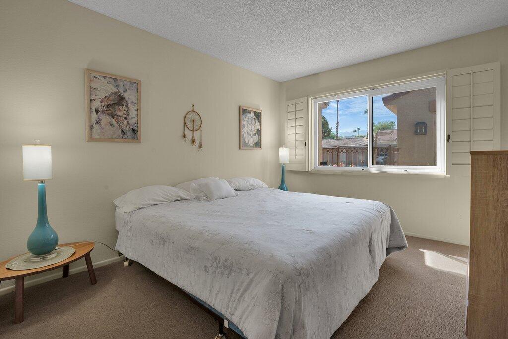 72302 Blueridge Court Palm Desert, CA 92260 - Photo 17 of 49 a bedroom with a bed and a large mirror