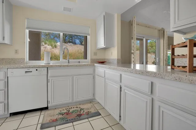 a white kitchen with sink and cabinets