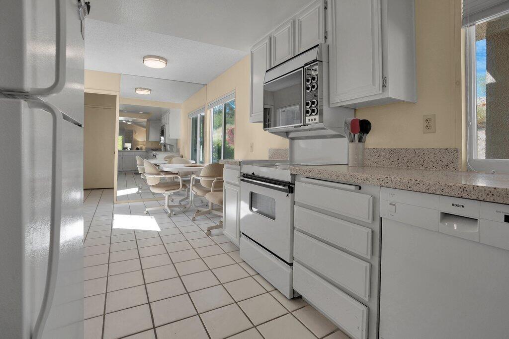 72302 Blueridge Court Palm Desert, CA 92260 - Photo 23 of 49 a kitchen with stainless steel appliances granite countertop a sink stove and cabinets