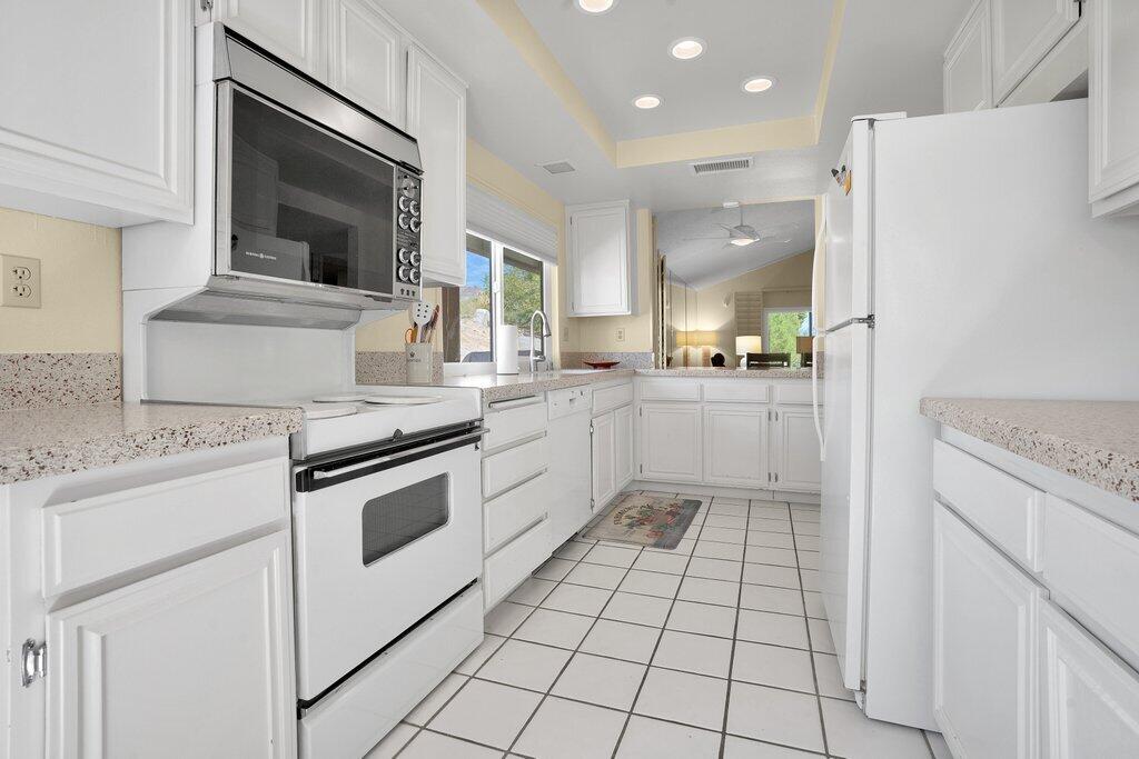 72302 Blueridge Court Palm Desert, CA 92260 - Photo 24 of 49 a kitchen with a stove a sink and a refrigerator