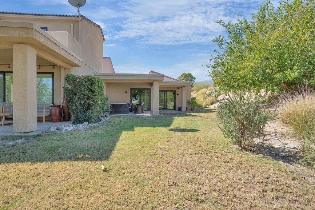 72302 Blueridge Court Palm Desert, CA 92260 - Photo 27 of 49 a view of a white house with a yard and potted plants