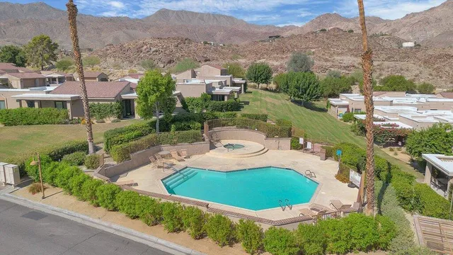 an aerial view of a house with a yard and a large tree