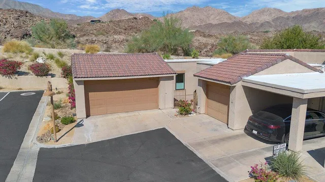 a front view of a house with a yard and mountain