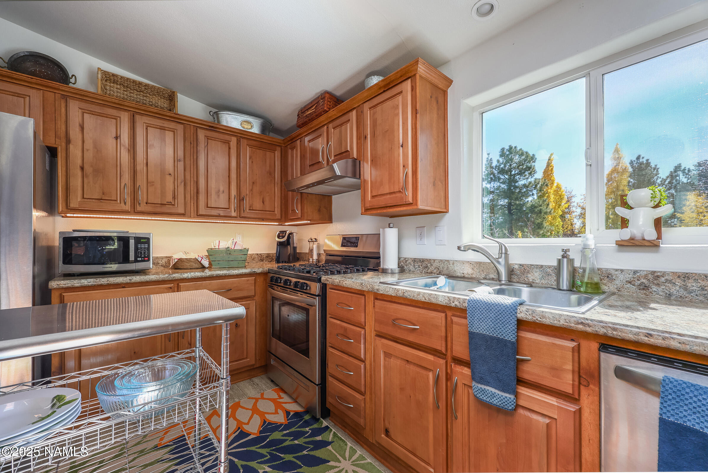 17265 Buffalo Run Munds Park, AZ 86017 - Photo 11 of 51 a kitchen with stainless steel appliances granite countertop a stove sink and cabinets