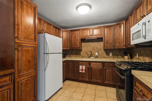 a kitchen with stainless steel appliances granite countertop a refrigerator and a stove