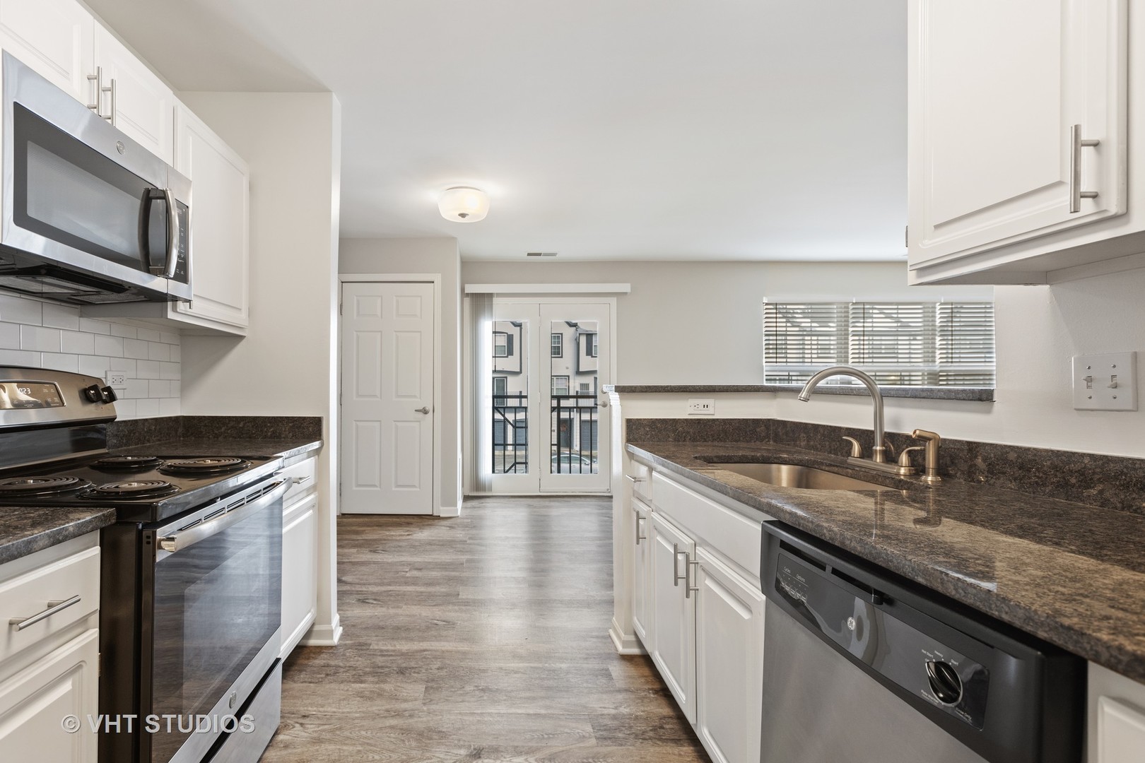 406 Mozart Court, Unit 406 Wheaton, IL 60189 - Photo 7 of 61 a kitchen with stainless steel appliances granite countertop a stove a sink and a microwave