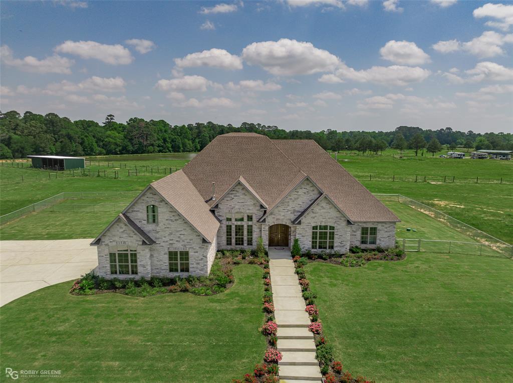 a aerial view of a house next to a big yard and large trees
