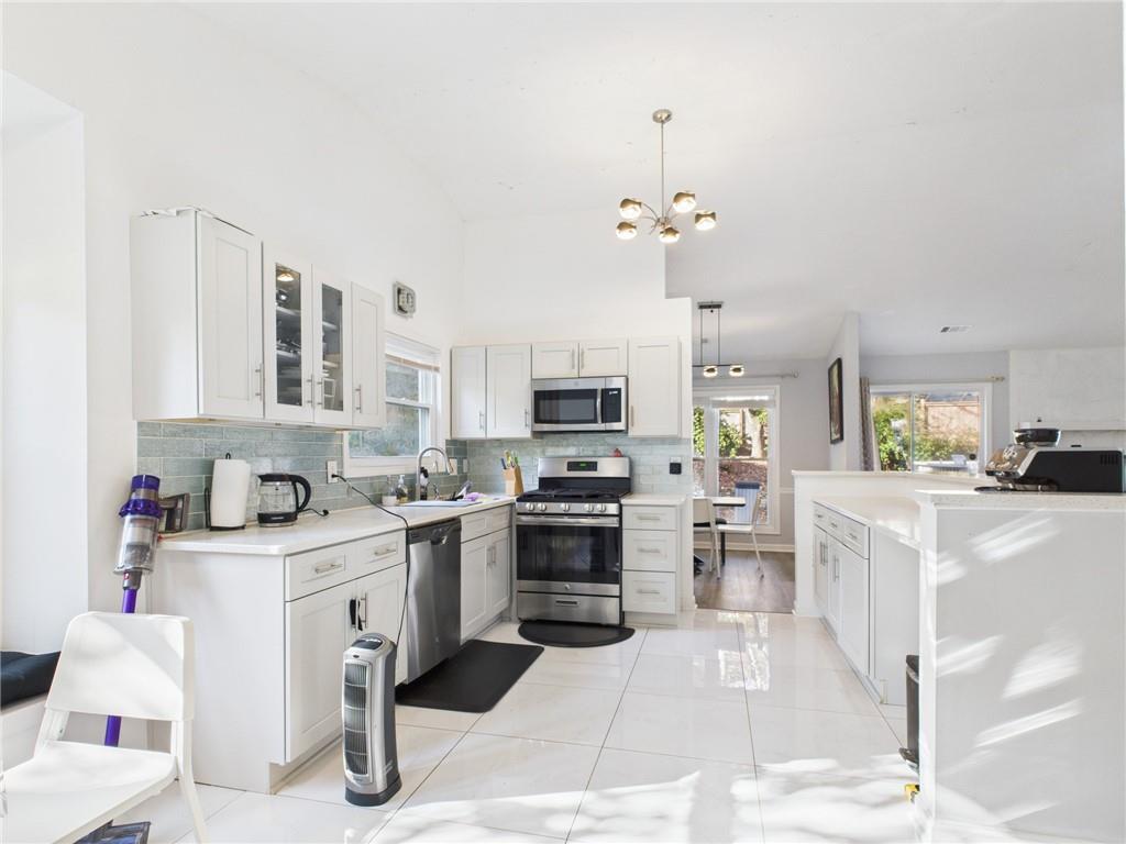 4060 Brooks Bridge Crossing Alpharetta, GA 30022 - Photo 12 of 30 a kitchen with stainless steel appliances kitchen island granite countertop a sink and cabinets