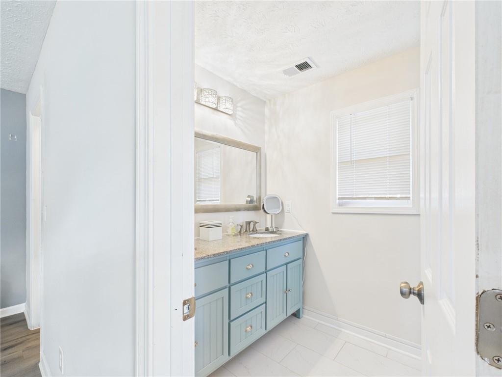 4060 Brooks Bridge Crossing Alpharetta, GA 30022 - Photo 25 of 30 a bathroom with a granite countertop sink mirror and a toilet