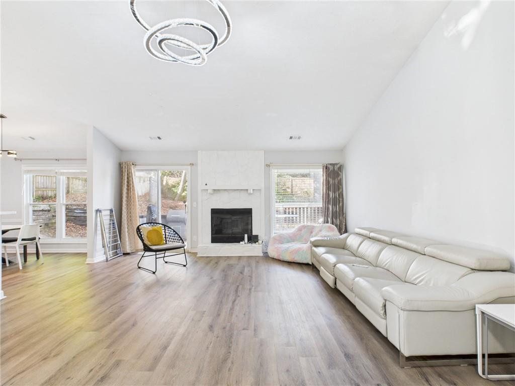 4060 Brooks Bridge Crossing Alpharetta, GA 30022 - Photo 3 of 30 a living room with furniture a fireplace and a floor to ceiling window