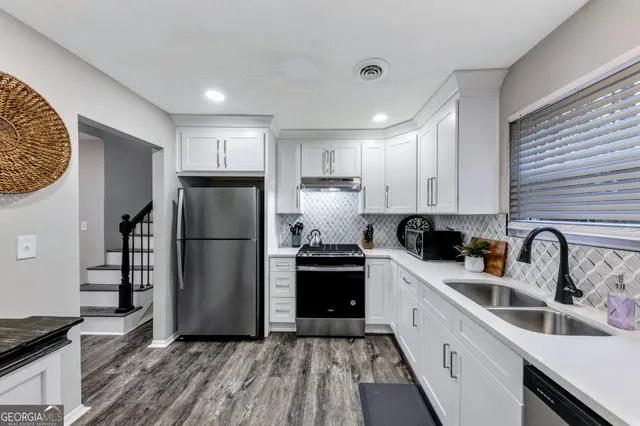 a kitchen with a sink a refrigerator and cabinets