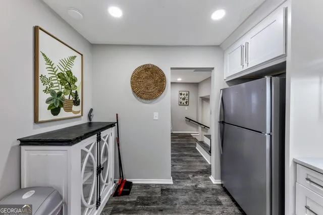 a kitchen with stainless steel appliances granite countertop a refrigerator a stove and a sink with wooden floor