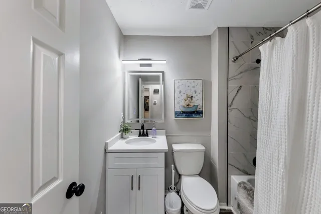 a bathroom with a toilet a sink and shower