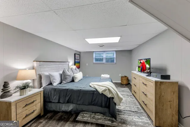 a bedroom with a large bed and a flat tv screen on the dresser