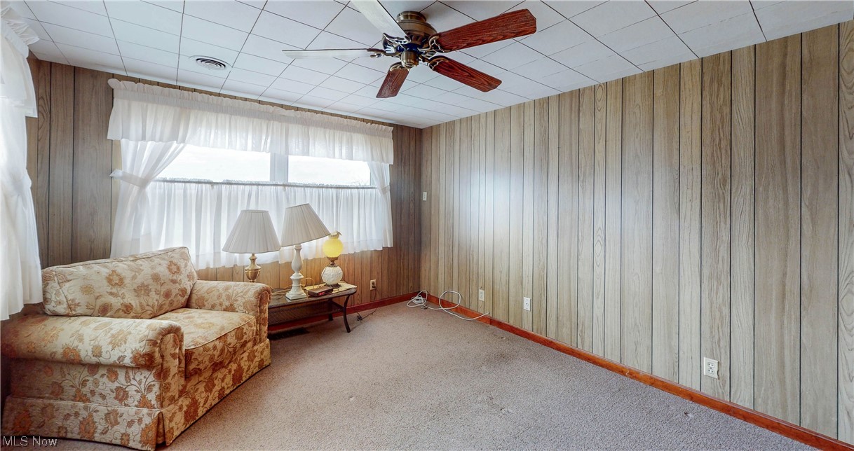466 Pine Lake Road Sebring, OH 44672 - Photo 25 of 30 Living area with wood walls, light colored carpet, and ceiling fan