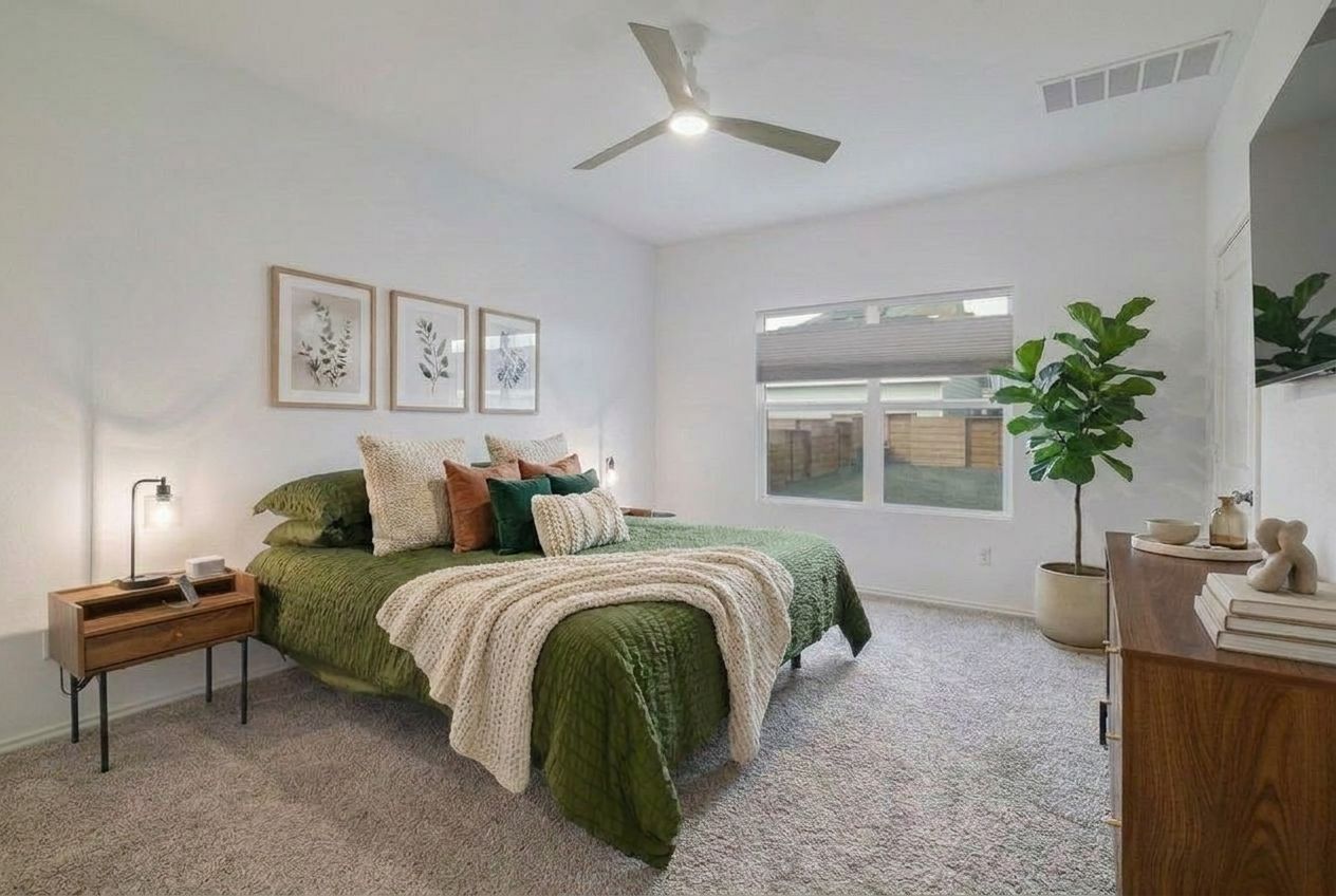 411 Jack Ryan Kyle, TX 78640 - Photo 12 of 30 a spacious bedroom with a bed and a chandelier