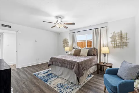a bedroom with a large bed chandelier and a window
