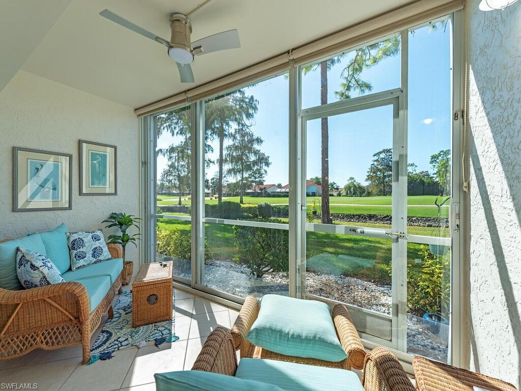 5950 Amherst Drive, Unit A106 Naples, FL 34112 - Photo 13 of 16 a living room with couch and a floor to ceiling window