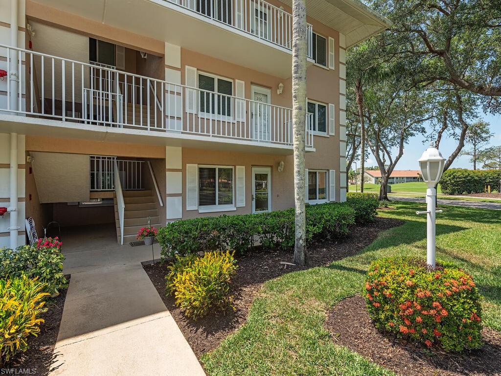 5950 Amherst Drive, Unit A106 Naples, FL 34112 - Photo 2 of 16 a house view with a garden space