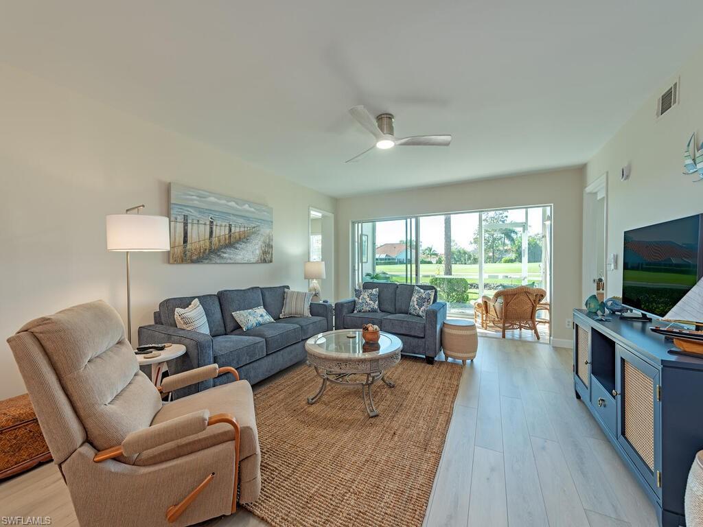 5950 Amherst Drive, Unit A106 Naples, FL 34112 - Photo 3 of 16 a living room with furniture and a flat screen tv