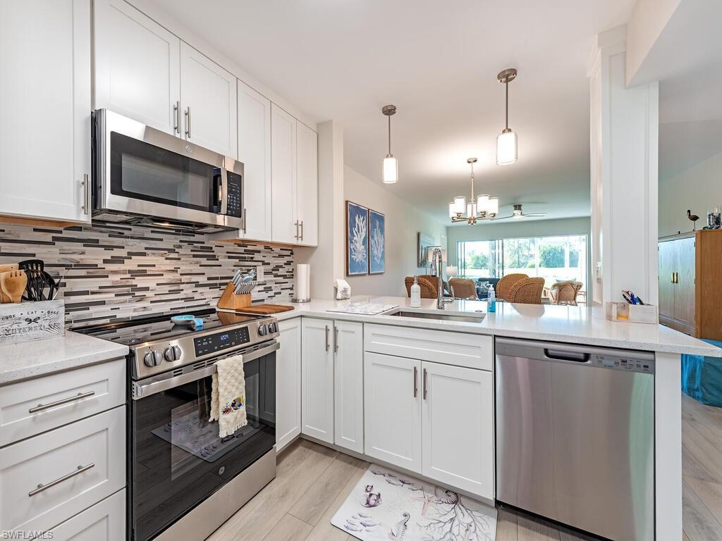 5950 Amherst Drive, Unit A106 Naples, FL 34112 - Photo 16 of 16 a kitchen with a sink stove and microwave