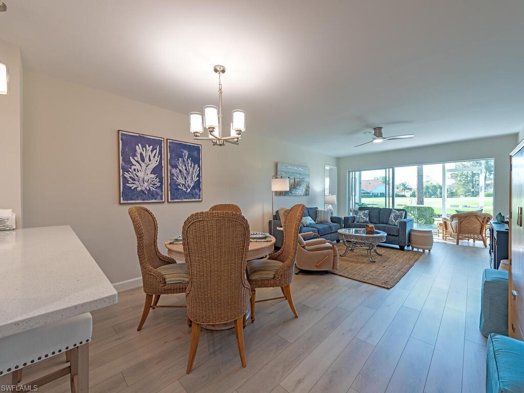 5950 Amherst Drive, Unit A106 Naples, FL 34112 - Photo 6 of 16 a view of a dining room with furniture window and wooden floor