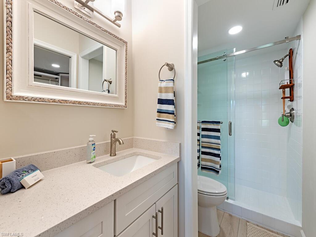 5950 Amherst Drive, Unit A106 Naples, FL 34112 - Photo 9 of 16 a bathroom with a sink a toilet and shower