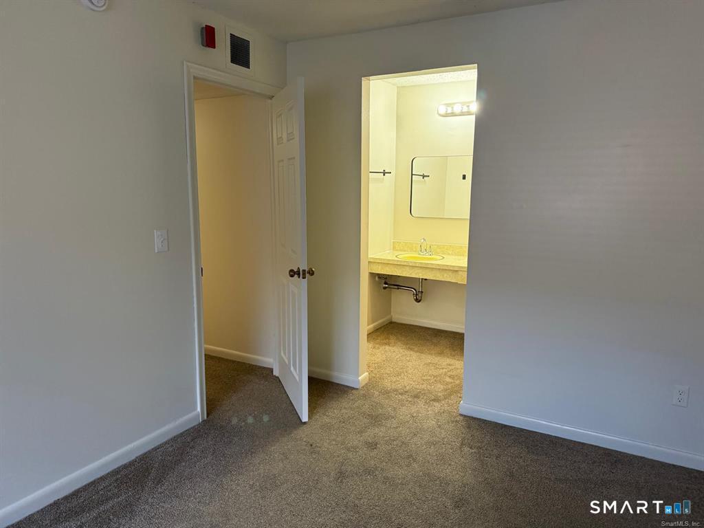 1274 East Main Street, Unit D12 Meriden, CT 06450 - Photo 5 of 14 an empty room with a door