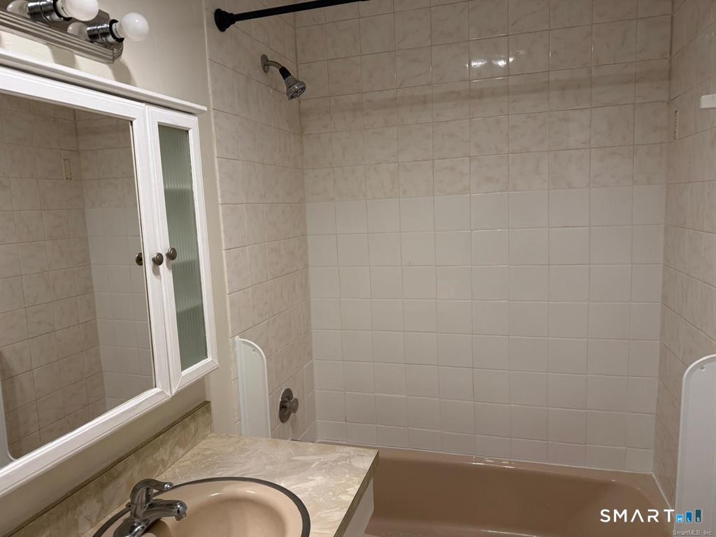 1274 East Main Street, Unit D12 Meriden, CT 06450 - Photo 10 of 14 a bathroom with a granite countertop sink and a mirror