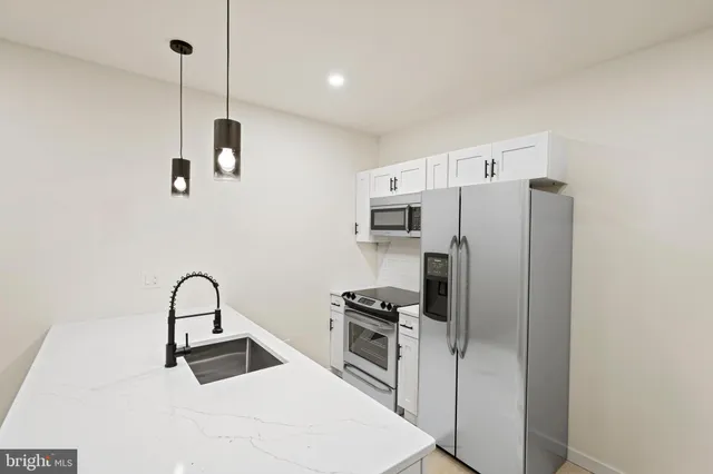 a kitchen with stainless steel appliances a refrigerator sink and microwave