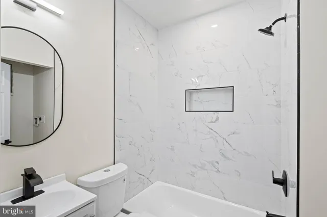 a bathroom with a toilet sink and a mirror