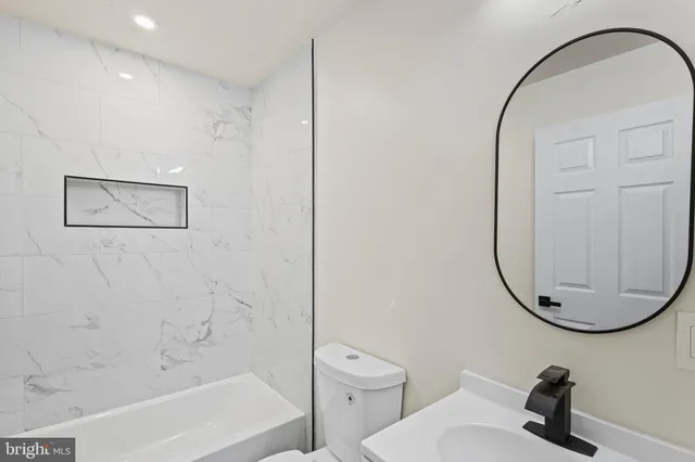 a bathroom with a sink a toilet and a mirror