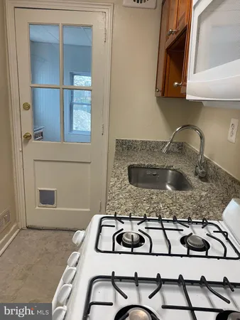 a kitchen with a sink a stove and cabinets