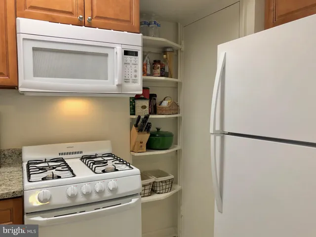 a white refrigerator freezer and a stove sitting inside of a kitchen