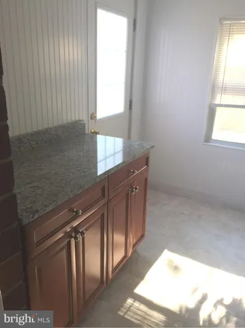 a kitchen with stainless steel appliances granite countertop a sink window and cabinets