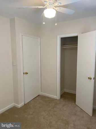 a view of an empty room and chandelier fan
