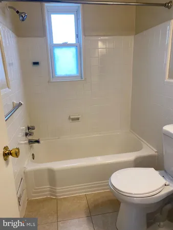 a bathroom with a toilet and a bath tub