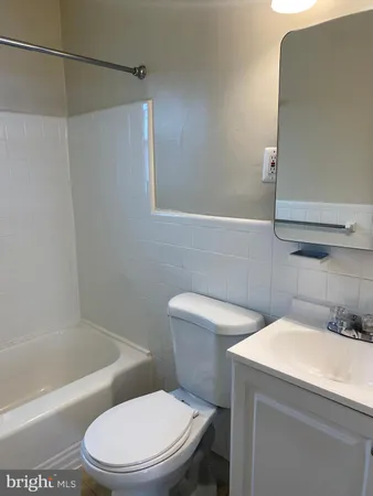 a white toilet sitting next to a bath tub