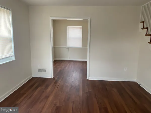 an empty room with wooden floor and a window