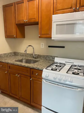 a white stove top oven sitting inside of a kitchen