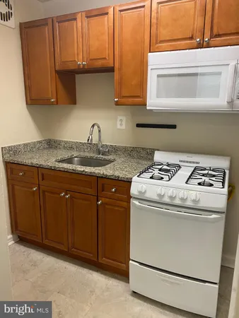 a kitchen with granite countertop cabinets stainless steel appliances and a sink