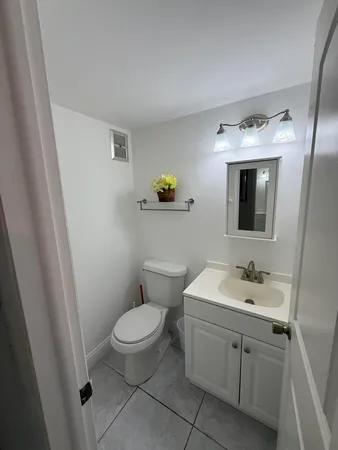 a bathroom with a toilet sink and mirror