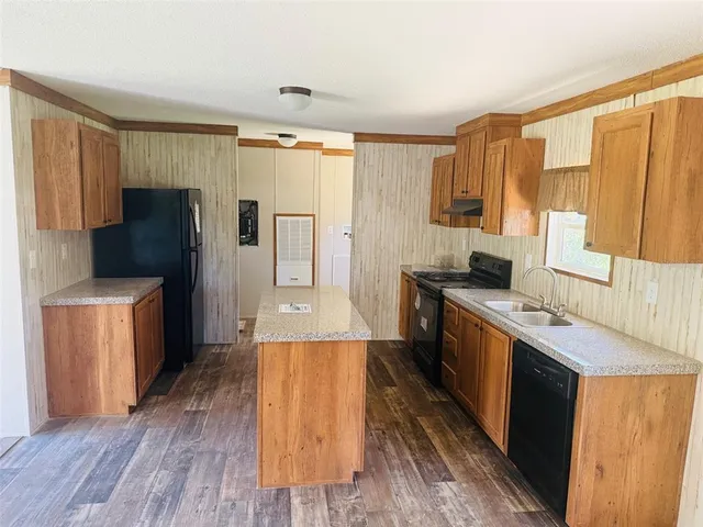a kitchen with a refrigerator a sink and wooden cabinets